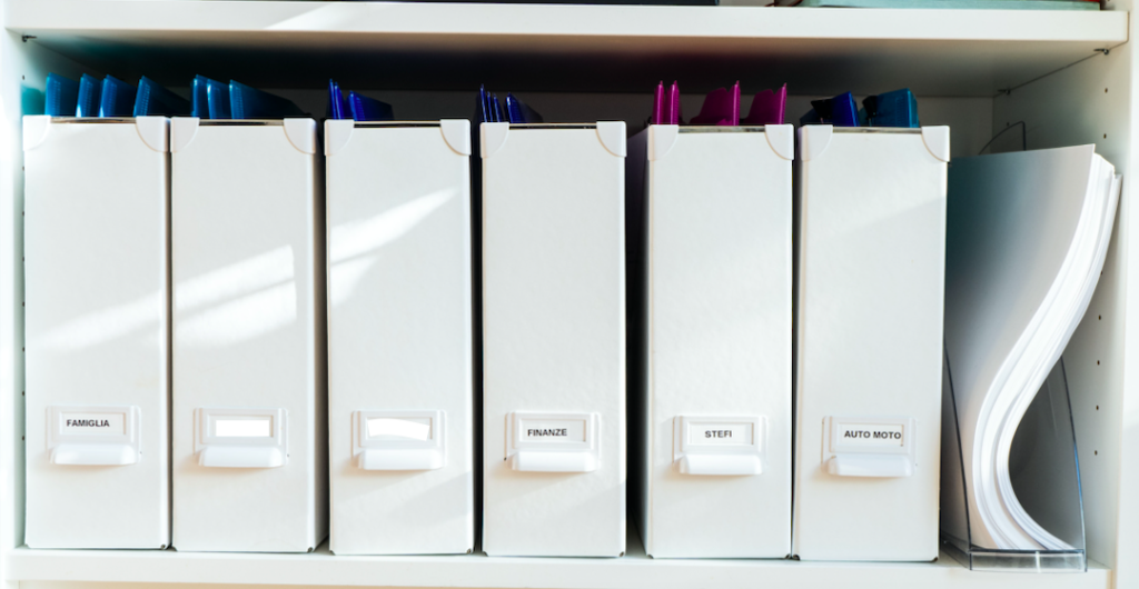 documenti cartacei organizzati in faldoni bianchi